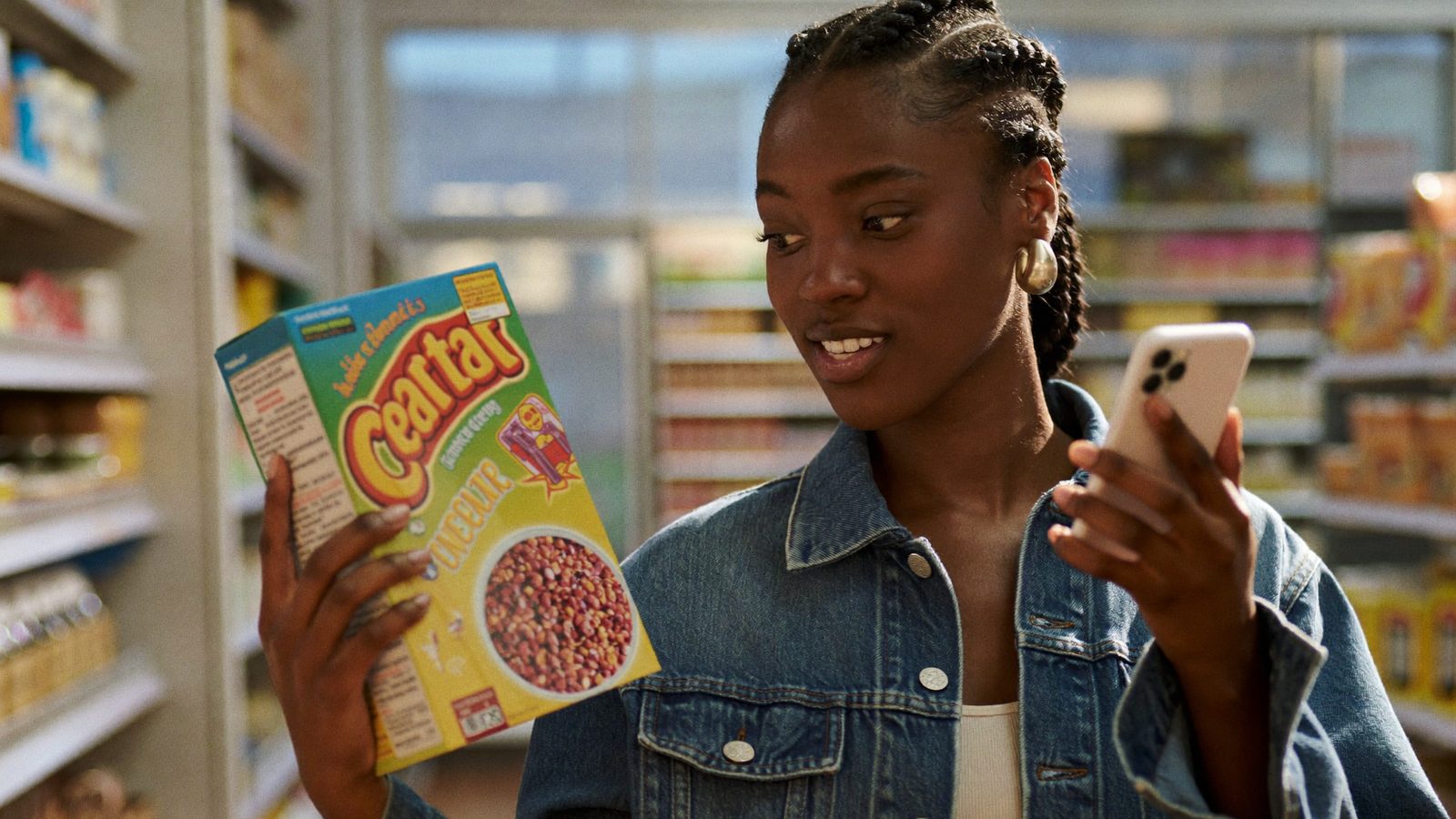 Woman comparing a cereal box with her food health scanner app in a grocery aisle